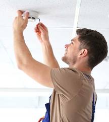 Technician installing a smoke detector